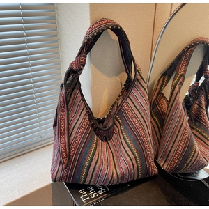 Detail of colorful bohemian striped knit hobo bag with unique knotted strap design