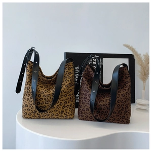 Close-up of leopard print tote bags with black leather straps and silver eyelets
