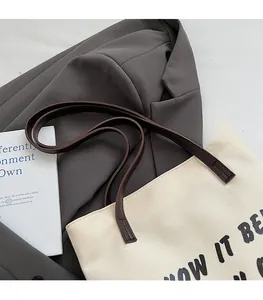 Détail du sac fourre-tout en toile avec anses plates marron et coutures renforcées