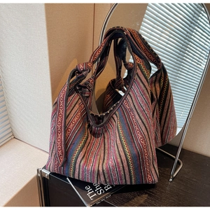 Detailed texture of colorful ethnic striped woven tote bag with a knotted wide shoulder strap