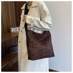 Close-up of leopard print tote bag with adjustable black wide strap and metal eyelets