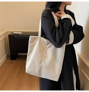 Detail of the soft corduroy fabric texture on a large beige shoulder tote bag