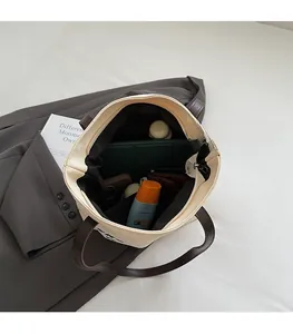 Vue intérieure du sac cabas en toile beige à grande capacité et anses en cuir marron