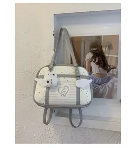 Detail of grey shoulder bag with white wings, star patterns and cute bird pendant