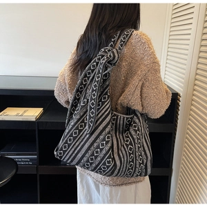 Detail view of large bohemian canvas tote bag with geometric knit patterns and knotted strap