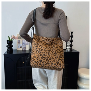 Close-up of leopard print tote bag with adjustable black strap and metal eyelets