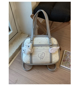 Detail of sweet Lolita style tote bag with heart emblem and plush bear charm