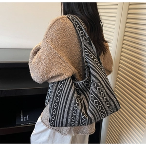 Close-up of woven tote bag with black and white geometric diamond and striped knit texture