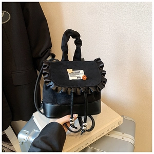 Detail of a black mini leopard textured backpack with ruffle trim and cute bear patch