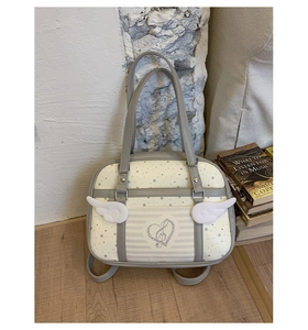 Detail of a chic cream Boston bag featuring white angel wings and star prints on a vintage rug
