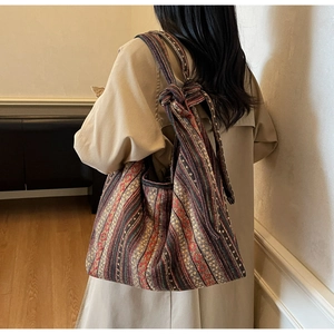 Close-up of bohemian striped woven tote bag shown on model with ethnic pattern details