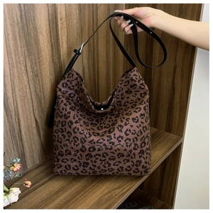 Detail of high-capacity leopard print hobo bag featuring black leather adjustable strap