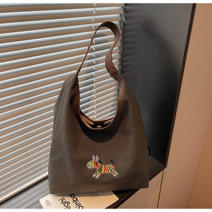 Detail of colorful zebra embroidery and brown leather strap on canvas tote bag