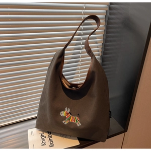 Detailed close-up of colorful zebra embroidery on the dark grey canvas tote bag