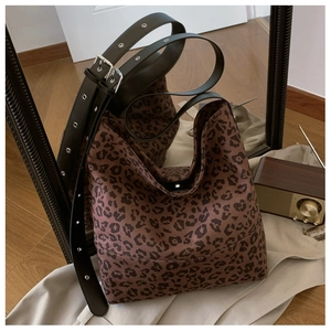 Detail of leopard print tote bag with adjustable black leather strap and silver metal buckle
