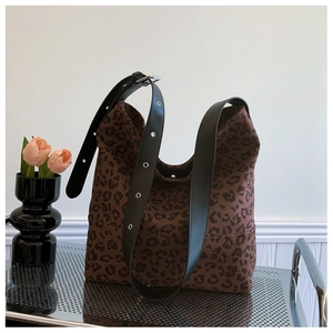 Detail of adjustable black leather strap and leopard print fabric on large tote bag