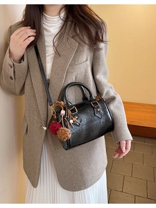 Vintage black cylinder Boston handbag with textured leather and decorative pompom charm