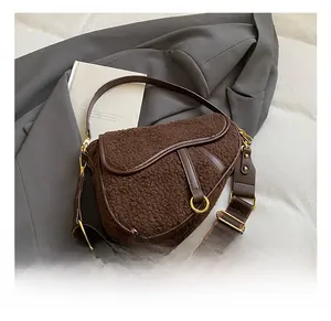 Detailed shot of brown teddy plush saddle bag with gold D-ring and leather accents