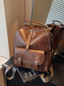 Vintage brown leather backpack with buckle front pocket and adjustable straps