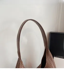 Detailansicht des bequemen braunen Leder-Schultergurts und der gewebten Textur der Handtasche