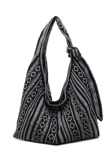 Ethnic knit crossbody bag with black and white geometric patterns and knotted shoulder strap