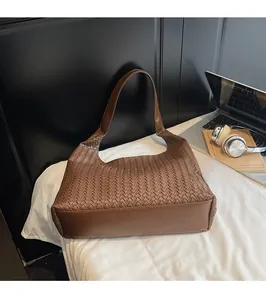 Detail der klassischen braunen gewebten Hobo-Tasche aus Leder mit Fokus auf Handwerkskunst