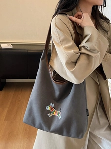 Large gray canvas tote bag with embroidered zebra pattern and brown leather straps