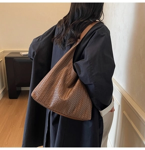 Braune gewebte Leder-Schultertasche am Modell gezeigt für Größe und Faltenwurf