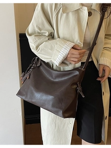 Retro brown leather hobo shoulder bag with knot strap and elephant charm on model