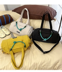 Detailansicht der Nylon-Reisetaschen mit dekorativen Knotenseilen in Creme, Schwarz und Gelb