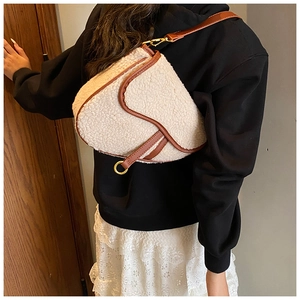 Detailed view of winter sherpa saddle bag with brown leather trim and gold metal rings