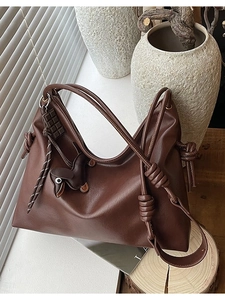 Brown leather shoulder bucket bag with chocolate charm and animal pendant detail