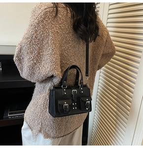 Detailed back view of a black lychee texture handbag with silver buckles and punk rivets