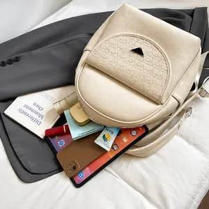 Detailed interior storage space of the beige lychee grain leather backpack with items