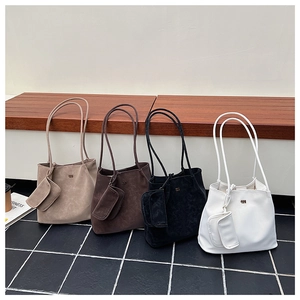 Vista dettagliata di quattro borse tote minimaliste in pelle con bustine coordinate