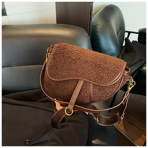 Detailed view of brown teddy plush saddle bag with leather trim and gold hardware