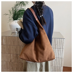 Detail of caramel suede hobo bag showing natural drape and spacious shoulder strap design