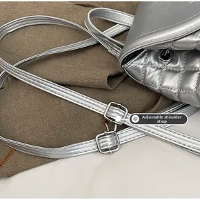 Detail of adjustable silver quilted leather shoulder strap with metallic buckle