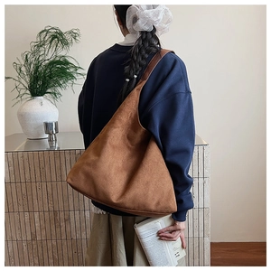 Brown leopard print large tote bag worn on shoulder in a minimalist indoor setting