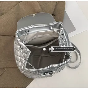 Internal view of silver quilted backpack showing gray herringbone lining and zipper pocket