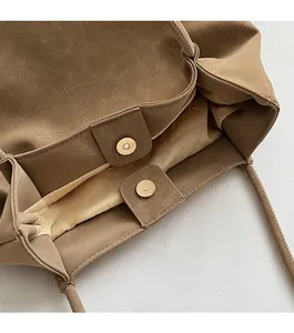Dettaglio della borsa tote in pelle kaki che mostra il design della doppia chiusura magnetica