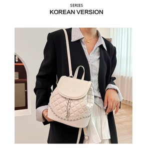 Close-up of quilted beige backpack with silver chain detail and elegant RDMAN logo