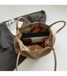 Dettaglio interno della borsa tote beige che mostra la grande capacità spaziosa