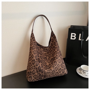 Detail of leopard print hobo tote bag with dark brown leather strap and soft fabric texture