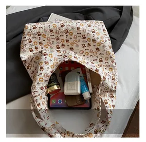 Detailed interior of a beige canvas tote bag showing storage capacity for tablet and cosmetics