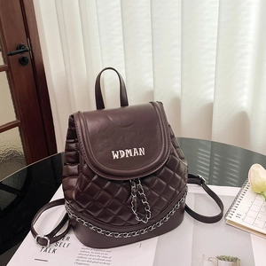 Detail view of chocolate brown quilted PU leather backpack with silver chain and embroidery