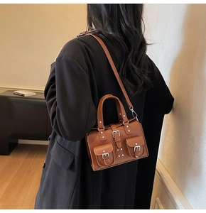 Detail of brown lychee texture leather shoulder bag with silver hardware and twin front pockets
