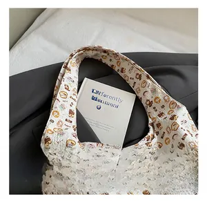 Detail showing the beige quilted tote bag with cute bear patterns and comfortable handle