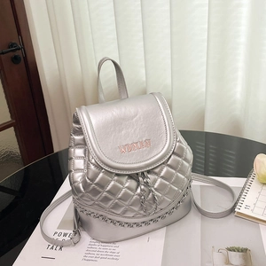 Detail of silver quilted mini backpack with metal chain and WOMAN lettering print