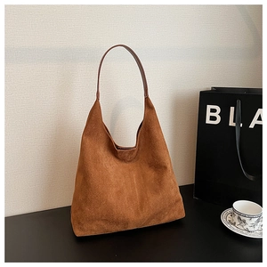 Close-up of brown suede hobo bag texture and elegant dark brown shoulder strap